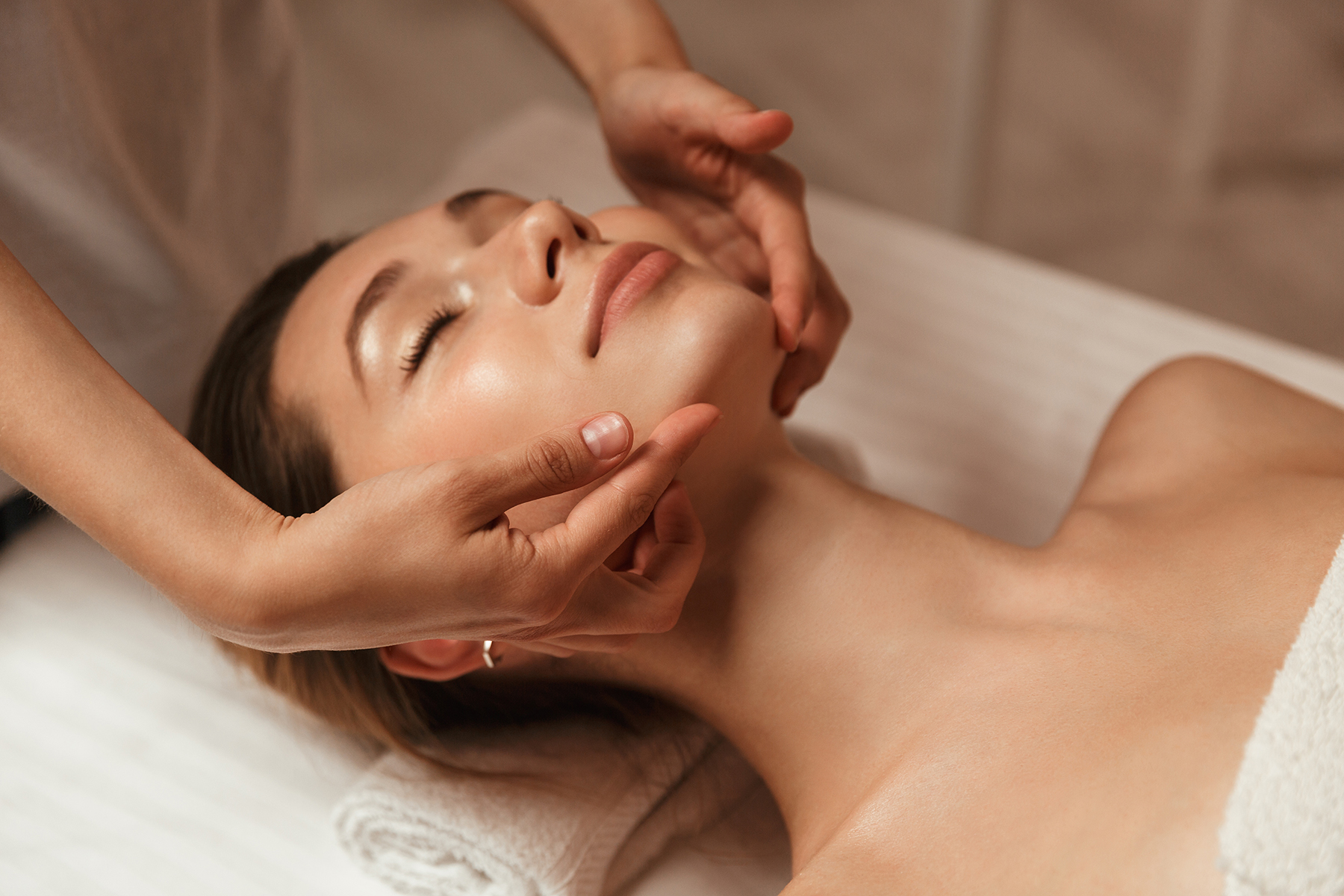 Young woman getting spa treatment with head massage at a spa center